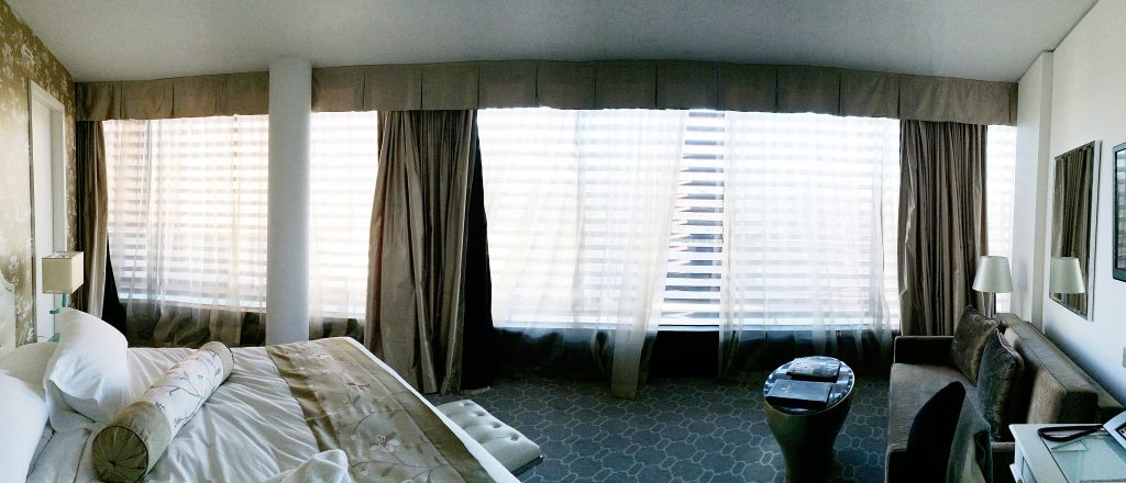 The panoramic view of the whole room in the morning. The room makes a quarter of a circle. 