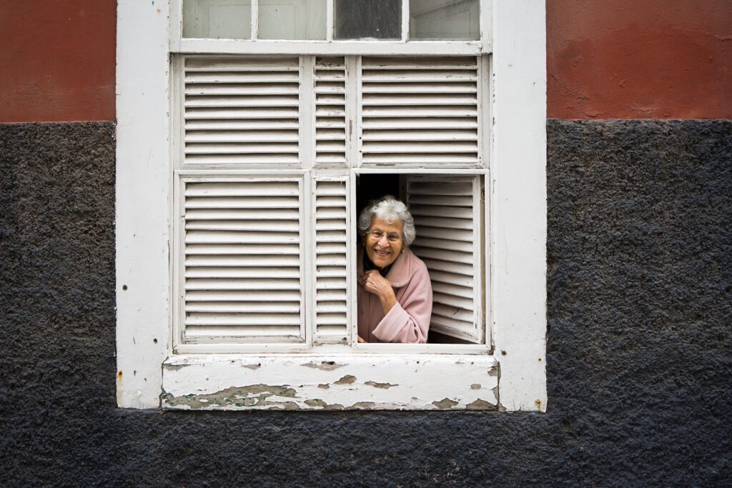 Old lady on the window of a house