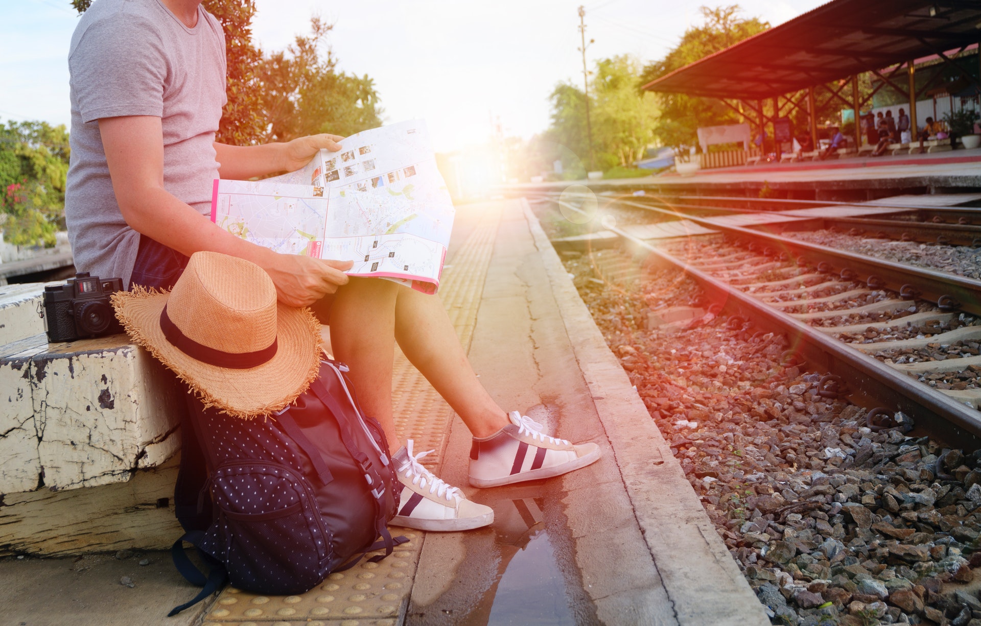 Backpack and traveler sitting near rails