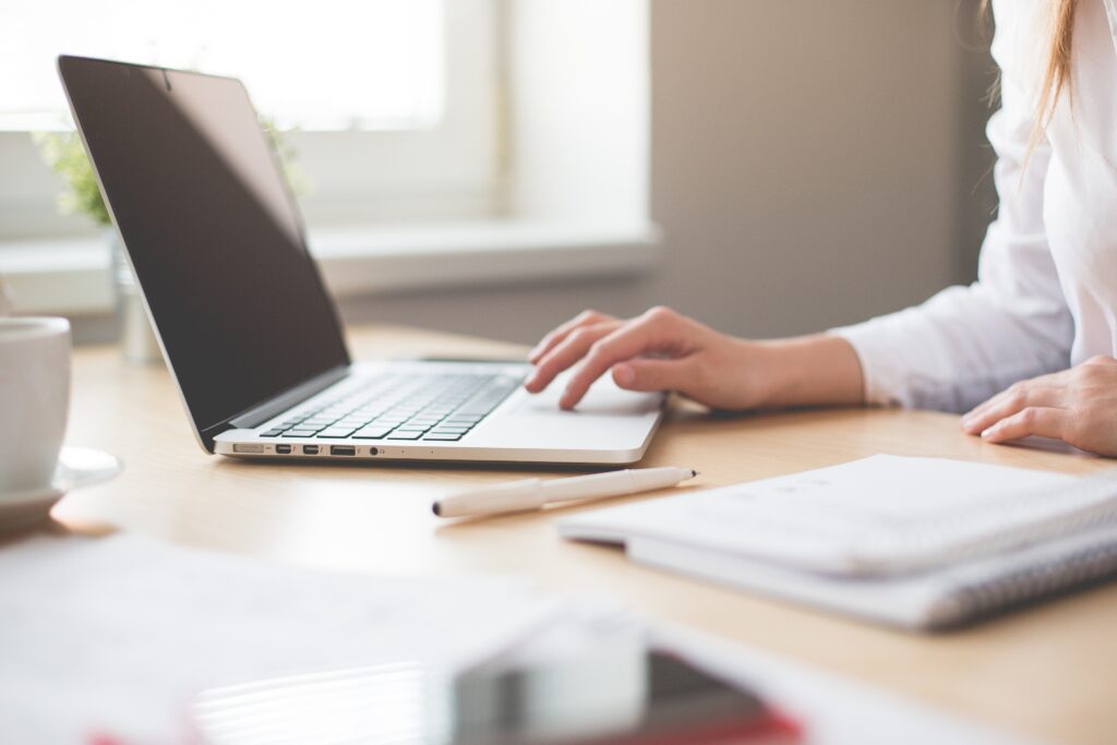 A person sitting behind a laptop trying to find a real estate agent.