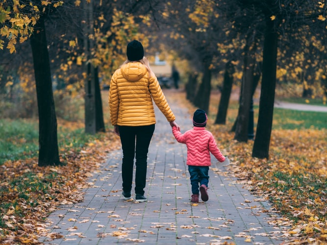 A mom enjoying her favorite fun exercise - walking with her little one.