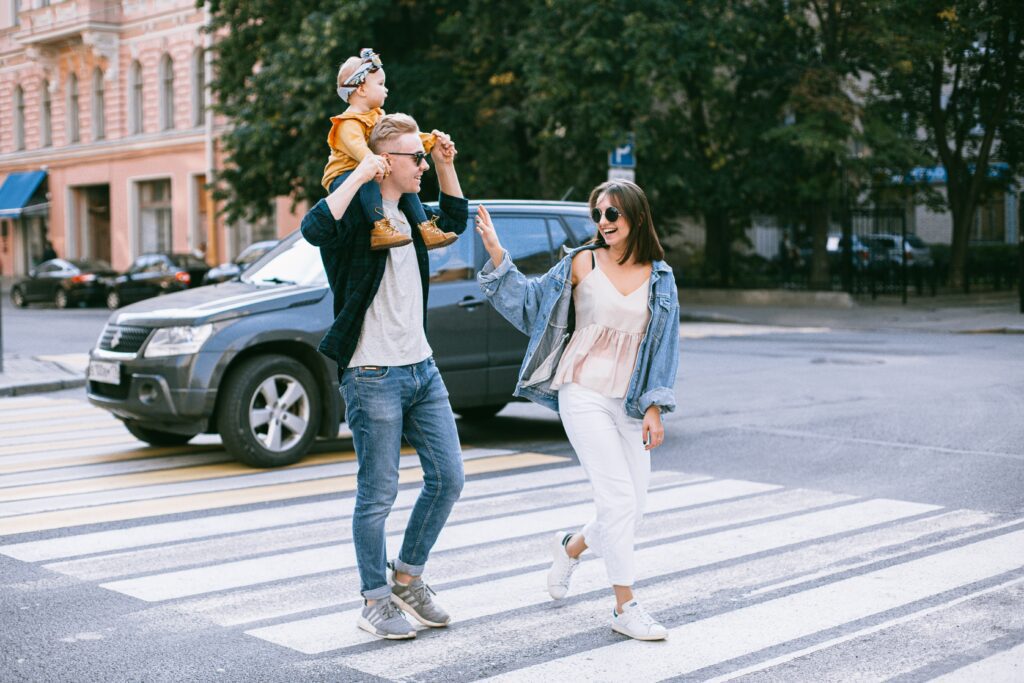 Mother and father crossing the street with their baby