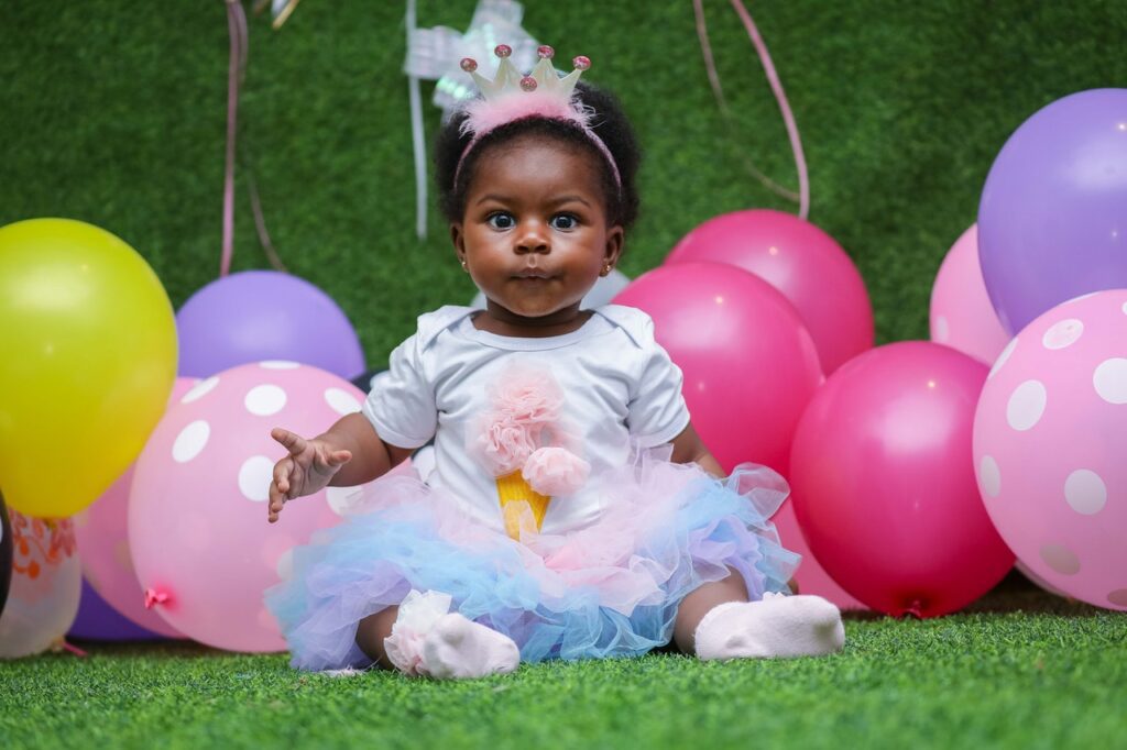 A baby girl celebrating her birthday in a birthday gown