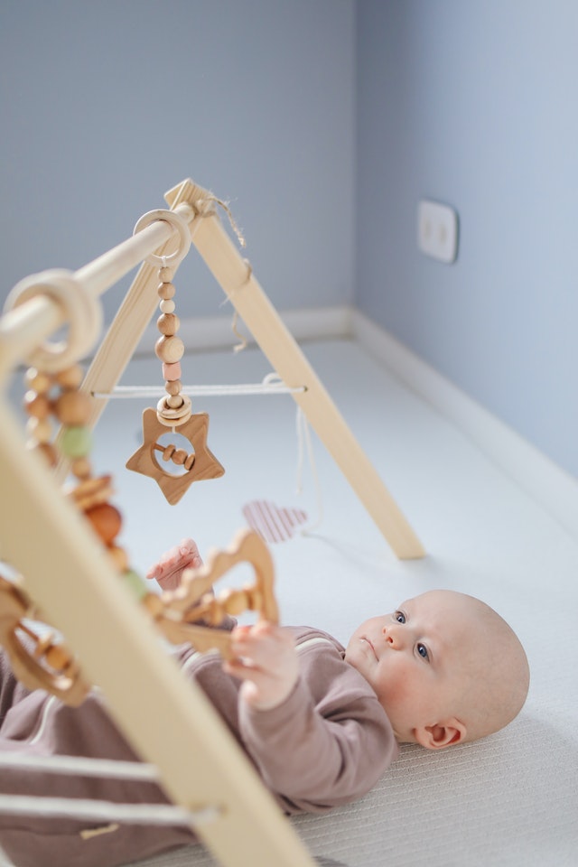 Baby playing with a wooden rattle