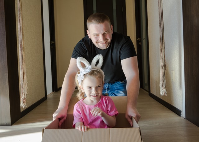 a man with a child in a cardboard box.