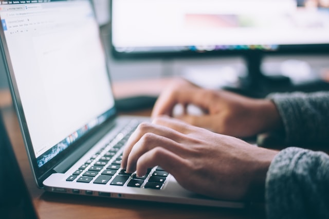 person using a laptop to check if buying a house in NYC is risky during the global pandemic