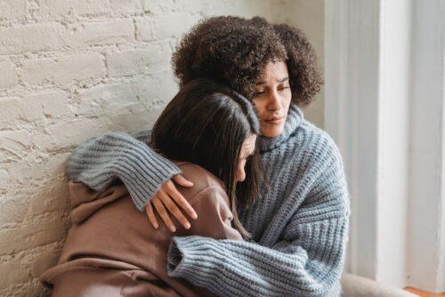 Sad women hugging.