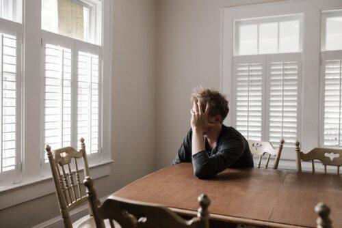 Depressed man sitting at a table.