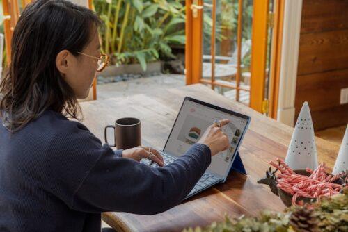 a person pointing at a laptop screen