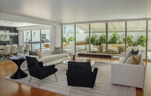 An open-plan living room and kitchen with white furniture