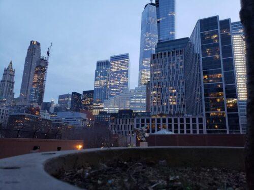 Skyscrapers in Lower Manhattan illuminated at dusk.