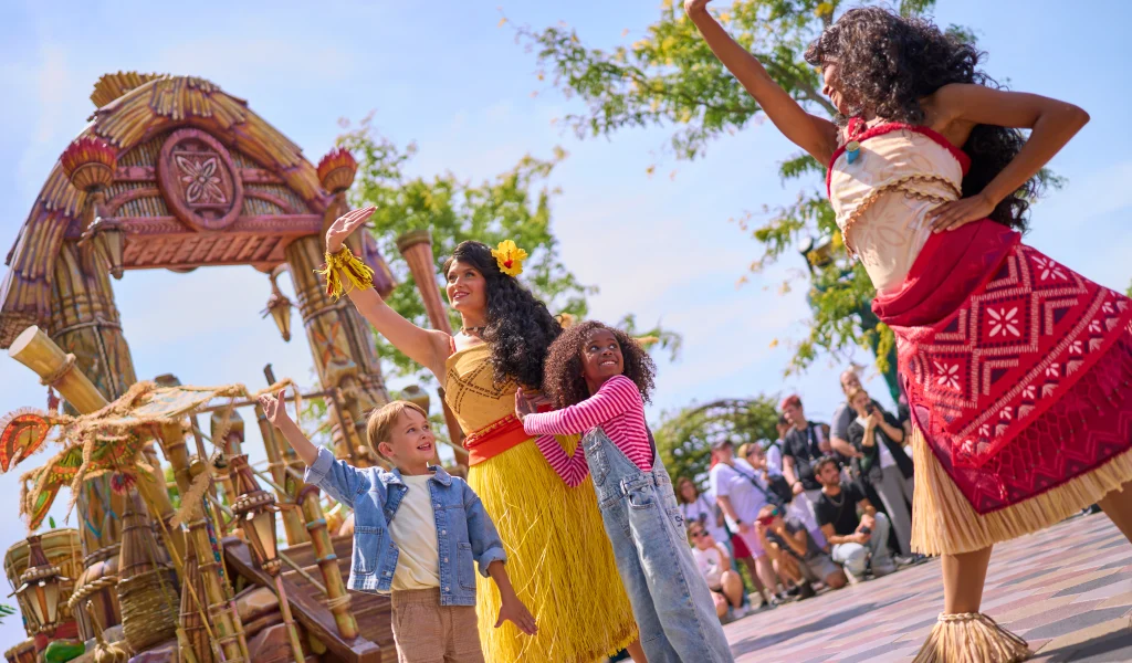Disney Princess Cavalcade performers dancing with children during an interactive parade at Disneyland Paris.