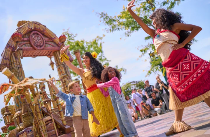 Disney Princess Cavalcade performers dancing with children during an interactive parade at Disneyland Paris.