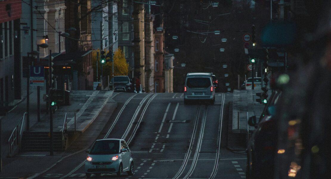 Compact car driving along an urban street with light traffic, highlighting the benefits of city living and easy commuting.
