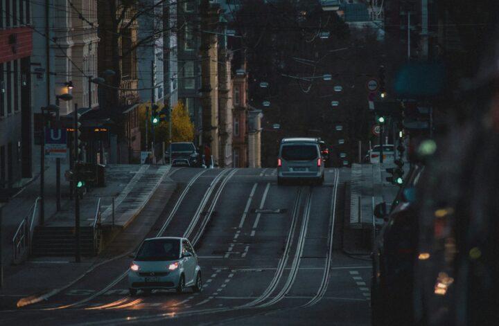 Compact car driving along an urban street with light traffic, highlighting the benefits of city living and easy commuting.