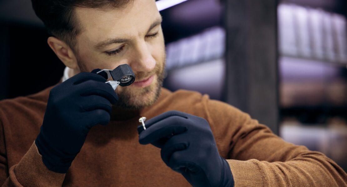 Jeweler inspecting a diamond ring with a loupe during a professional diamond appraisal.