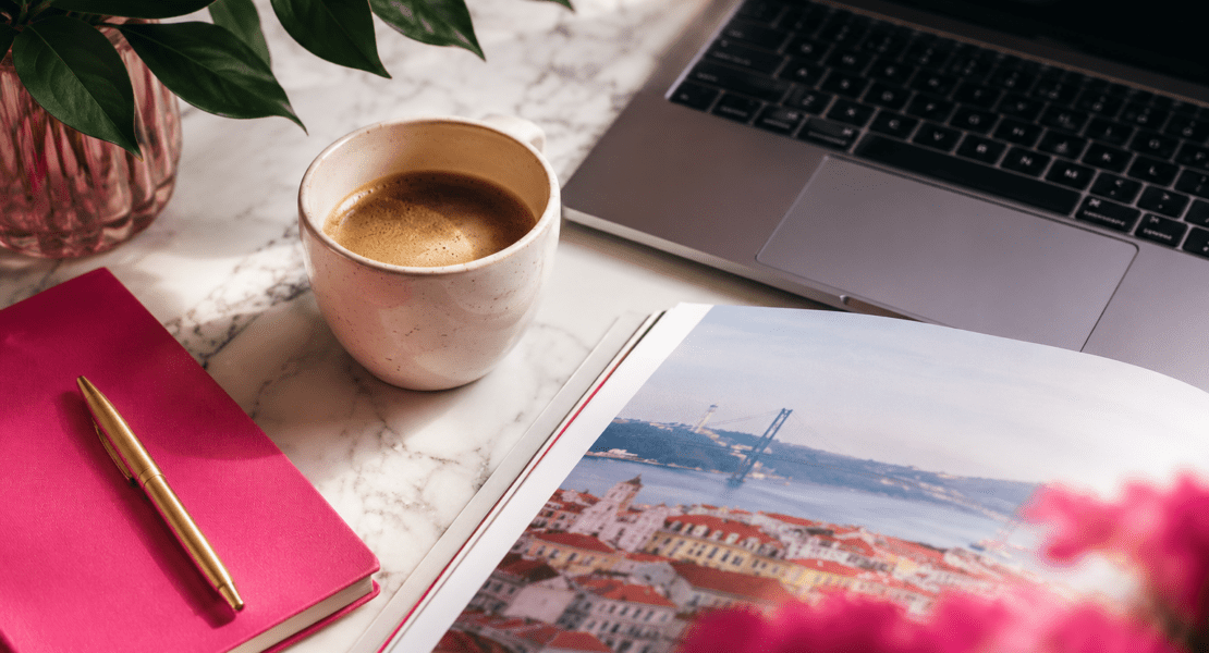 Mesa de trabalho com café, notebook e revista sobre negócios, marketing, tecnologia e lifestyle.