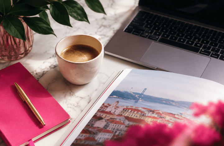 Mesa de trabalho com café, notebook e revista sobre negócios, marketing, tecnologia e lifestyle.