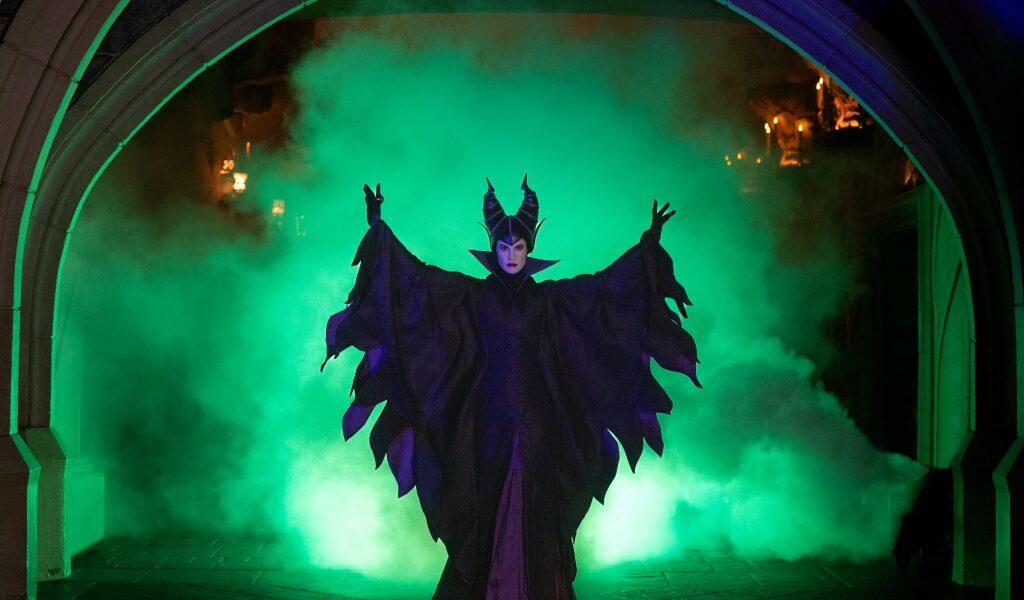 Horned Halloween character performing amid green smoke at Disneyland Paris during Halloween celebrations.