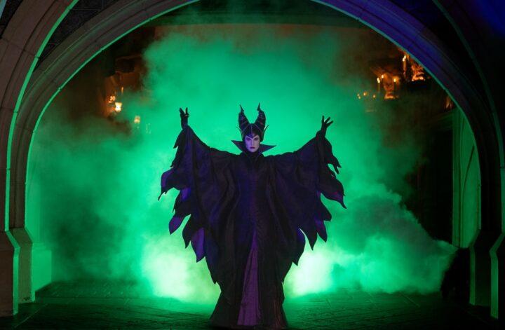 Horned Halloween character performing amid green smoke at Disneyland Paris during Halloween celebrations.