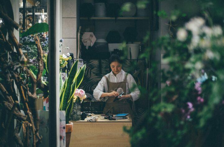 A small business owner working inside an established flower and plant shop.