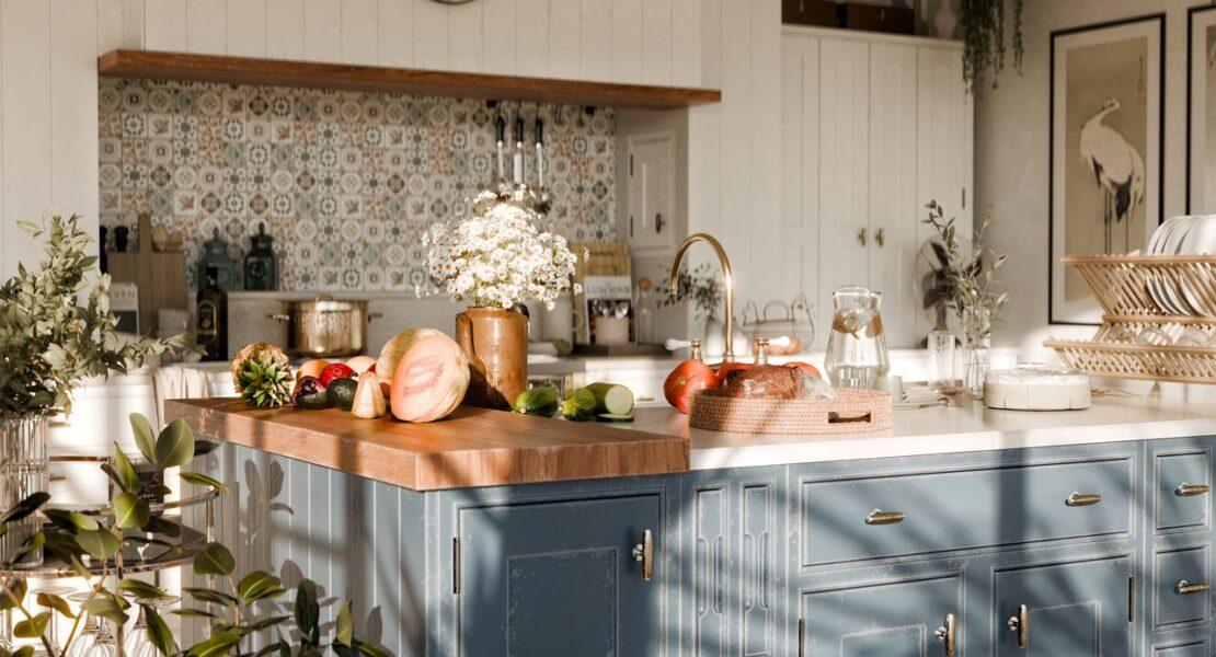 Bright kitchen with fresh fruit and vegetables displayed on a spacious island.
