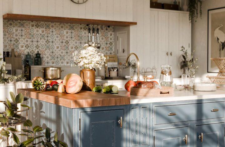 Bright kitchen with fresh fruit and vegetables displayed on a spacious island.